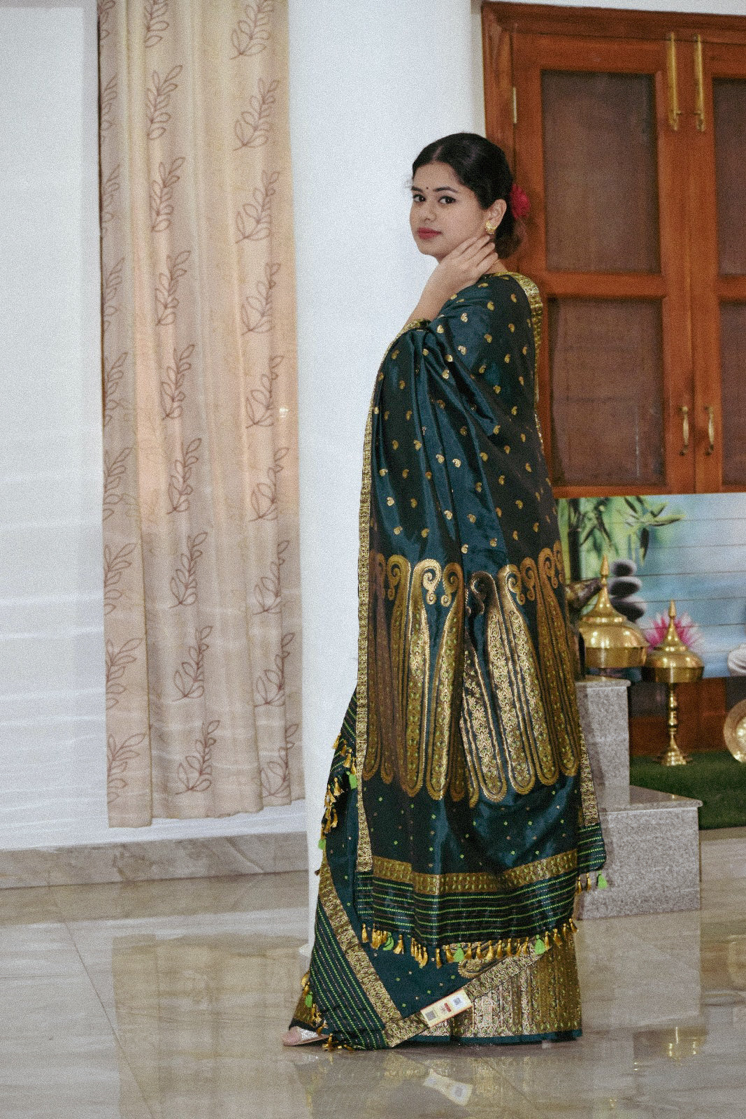 Dark green mulberry silk mekhela chador with golden zari paisley motifs, handcrafted in Guwahati.